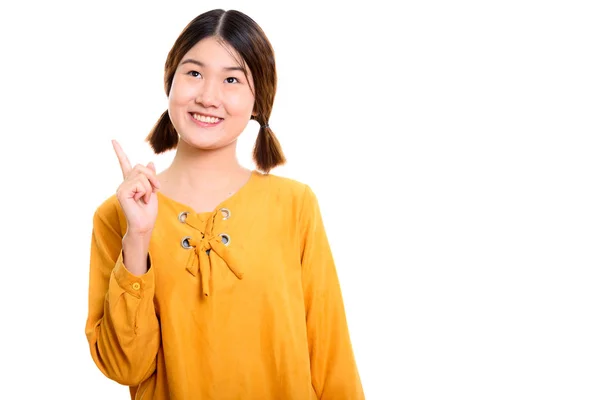 Doordachte jonge gelukkig Aziatische vrouw die lacht terwijl wijzende vinger — Stockfoto