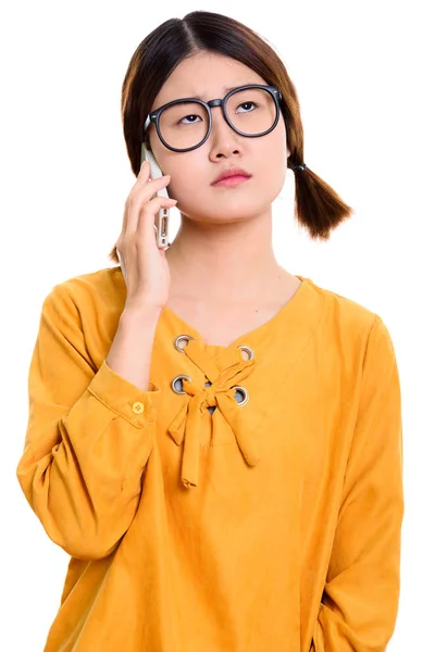 Молодая скучающая азиатка разговаривает по мобильному телефону — стоковое фото