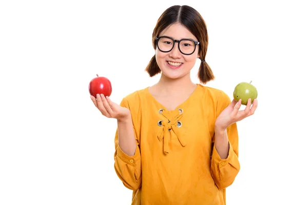 Boldog fiatal ázsiai nő mosolyogva, miközben piros alma és a zöld gazdaság — Stock Fotó