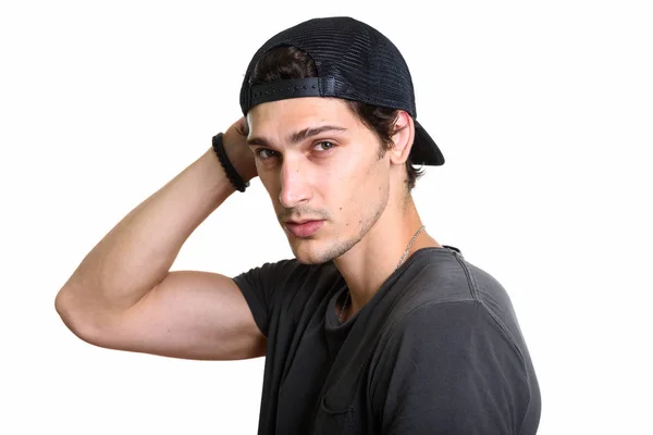 Studio shot of young handsome man wearing snapback while posing — Stock Photo, Image