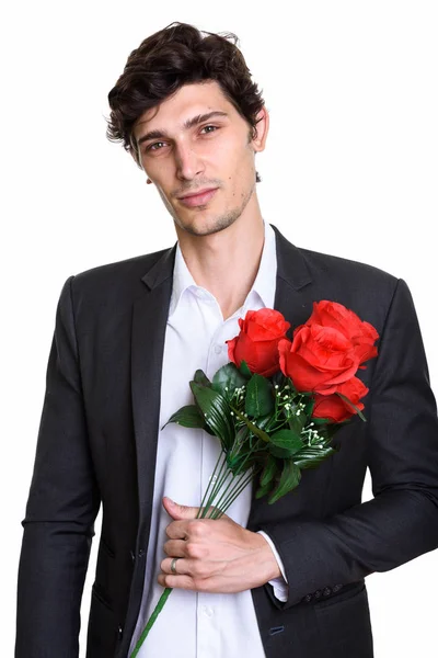 Stúdió lövés fiatal jóképű üzletember kezében vörös rózsa — Stock Fotó