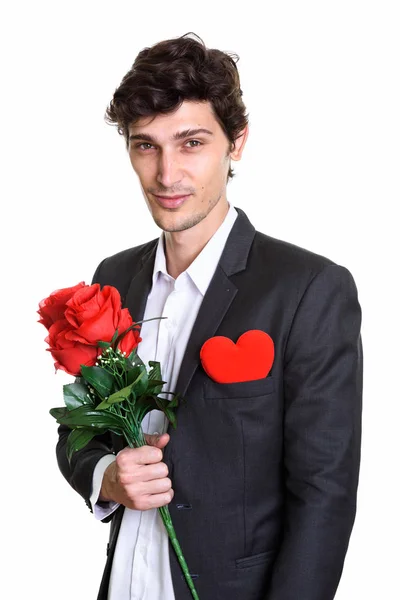 Studio skott av ung stilig affärsman holding röda rosor med — Stockfoto