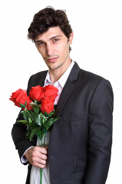 Estúdio tiro de jovem empresário bonito segurando rosas vermelhas perto — Fotografia de Stock