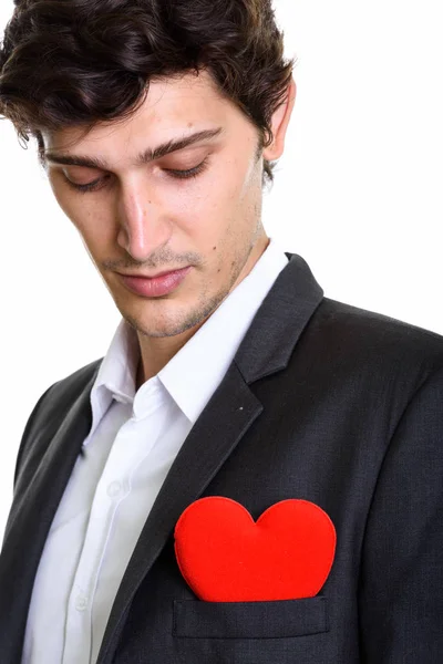 Nahaufnahme eines jungen, gut aussehenden Geschäftsmannes, der ein rotes Herz auf c betrachtet — Stockfoto
