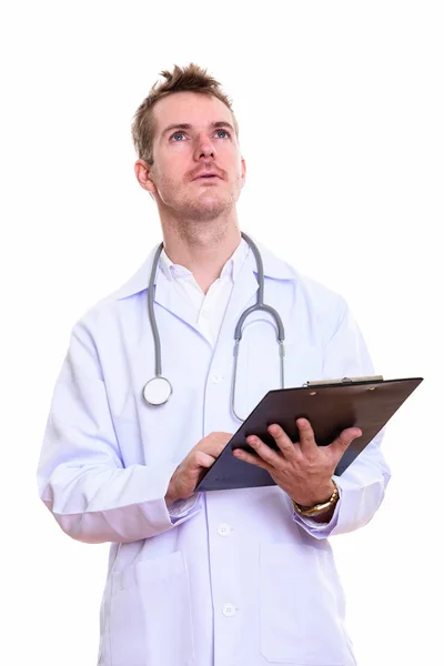 Студийный снимок врача, держащего планшет, думая: — стоковое фото