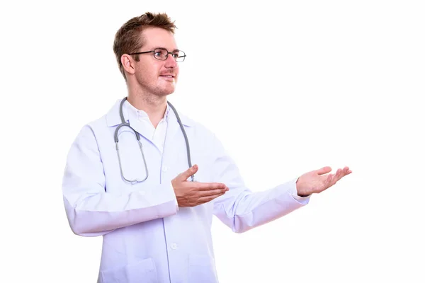 Estúdio tiro de homem feliz médico sorrindo ao mostrar algo — Fotografia de Stock