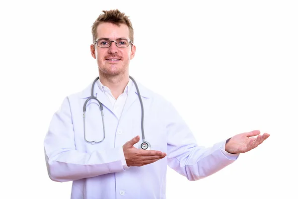 Studio záběr šťastný muž lékař se usmívá, zatímco ukazuje něco — Stock fotografie
