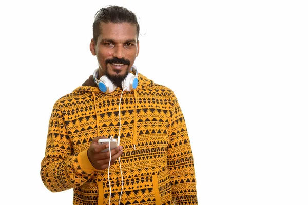 Jovem homem indiano feliz sorrindo enquanto segurando o telefone celular e nós — Fotografia de Stock