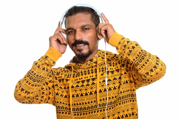 Young happy Indian man smiling while listening to music — Stock Photo, Image
