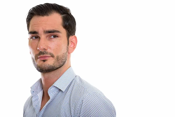 Studio shot of young handsome businessman thinking while looking — Stock Photo, Image