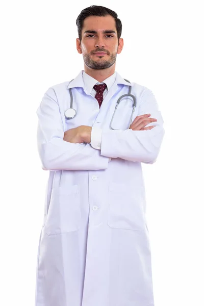 Studio shot of young handsome man doctor standing with arms cros — Stock Photo, Image
