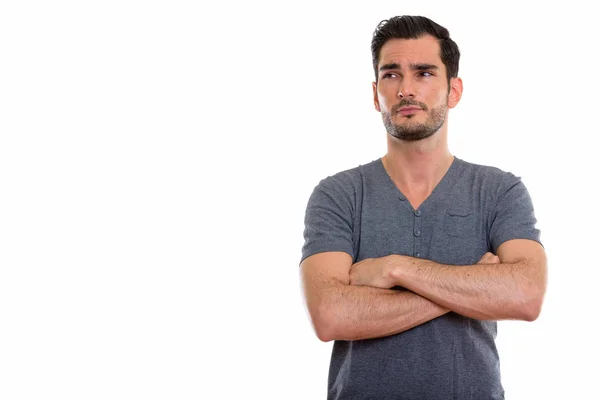 Studio shot of young handsome man thinking while looking at dist — Stock Photo, Image