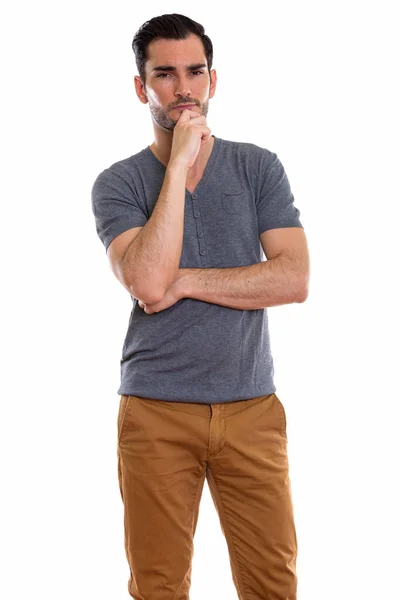 Studio shot of young handsome man standing while thinking — Stock Photo, Image