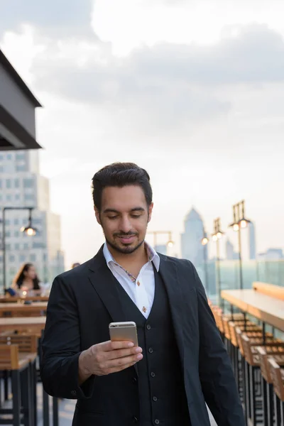 Jeune homme d'affaires indien heureux souriant tout en utilisant le téléphone mobile — Photo