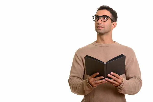 Giovane felice uomo caucasico che tiene libro mentre pensa — Foto Stock