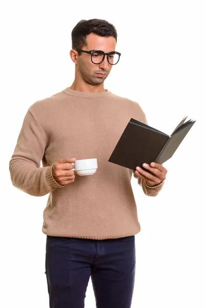 Pemuda tampan Kaukasia membaca buku sambil memegang kopi c — Stok Foto