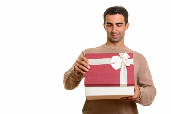 Молодой счастливый кавказский мужчина открывает подарочную коробку, готовый к дню Святого Валентина — стоковое фото