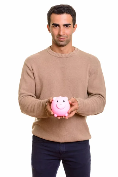 Young handsome Caucasian man holding piggy bank — Stock Photo, Image