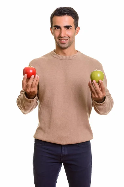 Joven feliz hombre caucásico sosteniendo manzana roja y verde — Foto de Stock