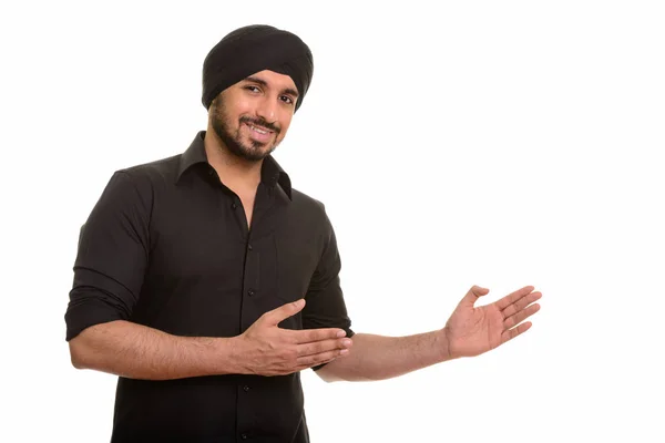 Joven feliz indio Sikh mostrando algo — Foto de Stock