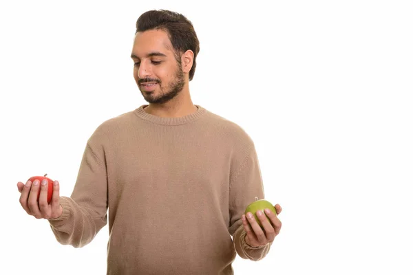 Jovem homem indiano feliz escolhendo entre maçã vermelha e verde — Fotografia de Stock