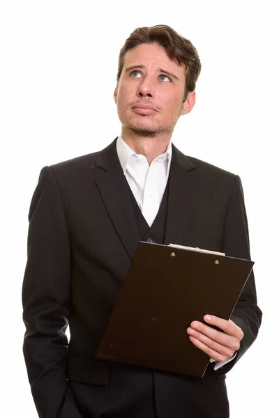 Guapo caucásico hombre de negocios pensando mientras sostiene portapapeles —  Fotos de Stock