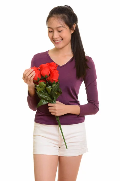 Młody szczęśliwy Azjatyckie dziewczyny nastoletnie uśmiechający się gospodarstwie czerwone róże gotowe f — Zdjęcie stockowe