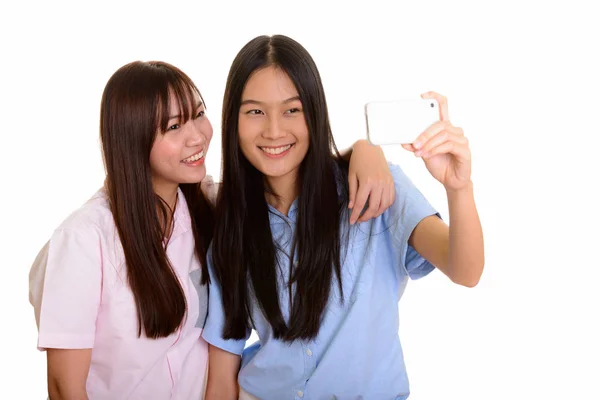 Twee jonge gelukkig Aziatische tienermeisjes glimlachend en het nemen van de selfie wi — Stockfoto