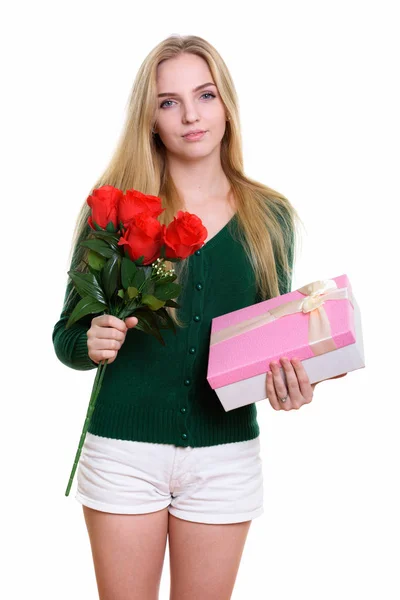 Студійний знімок молодої красивої дівчини-підлітка, що тримає червоні троянди — стокове фото