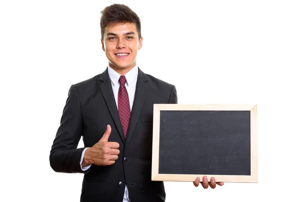 Joven hombre de negocios feliz sonriendo mientras sostiene pizarra en blanco un — Foto de Stock