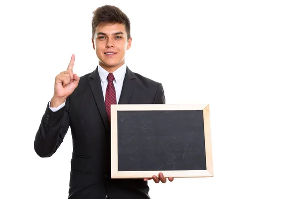 Joven hombre de negocios feliz sonriendo mientras sostiene pizarra en blanco un — Foto de Stock