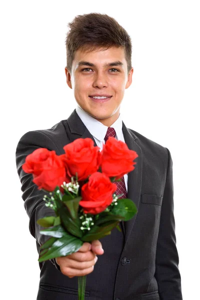 Joven hombre de negocios feliz sonriendo mientras da rosas rojas listo para —  Fotos de Stock