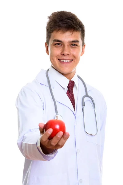 Studio shot of young happy man doctor smiling while giving red a — Stock Photo, Image