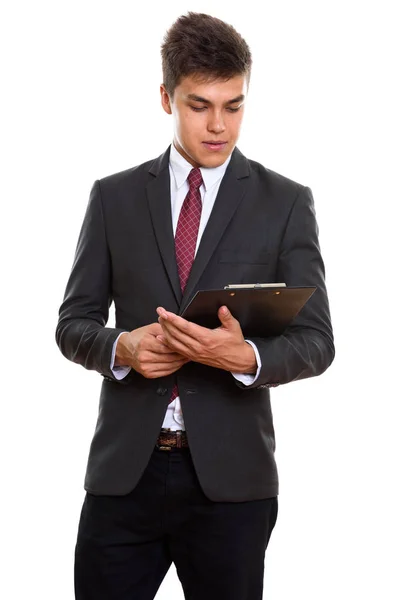 Junger gutaussehender Geschäftsmann steht beim Lesen auf Klemmbrett — Stockfoto