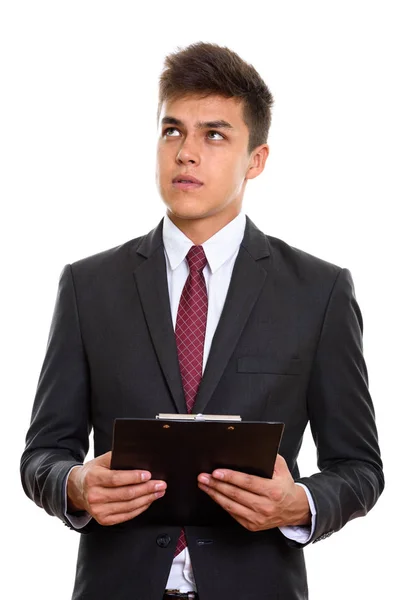 Joven hombre de negocios guapo sosteniendo portapapeles mientras piensa — Foto de Stock