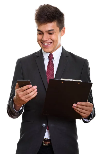 Young happy businessman smiling while using mobile phone and hol — Stock Photo, Image