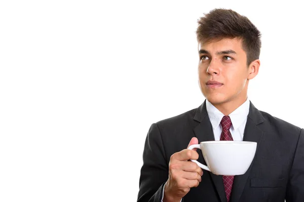 Joven hombre de negocios guapo sosteniendo la taza de café mientras piensa — Foto de Stock