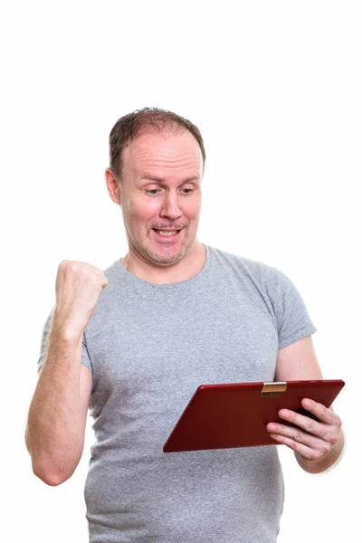 Студийный снимок счастливого зрелого мужчины, улыбающегося, держа в руках цифровую тарелку — стоковое фото