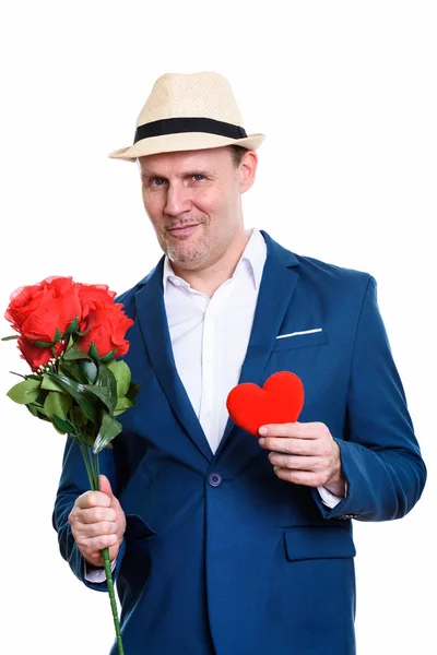 Estudio de maduro empresario sosteniendo rosas rojas y corazón re —  Fotos de Stock