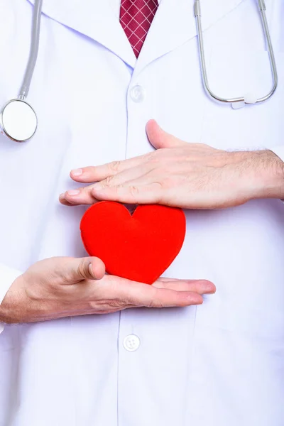Студийный снимок зрелого мужчины-врача с красным сердцем — стоковое фото