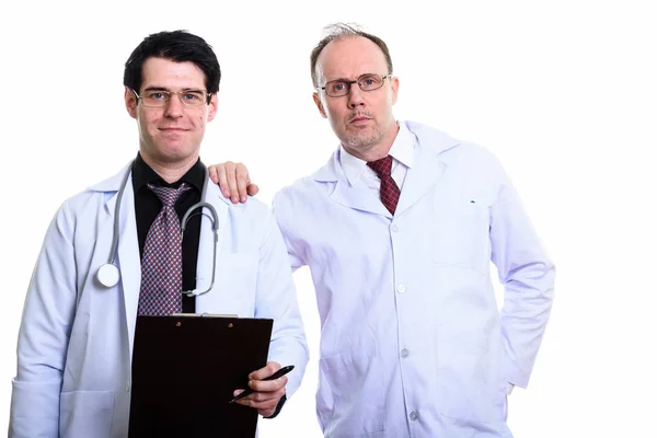 Mature man doctor with hand on shoulder of young man doctor hold — Stock Photo, Image