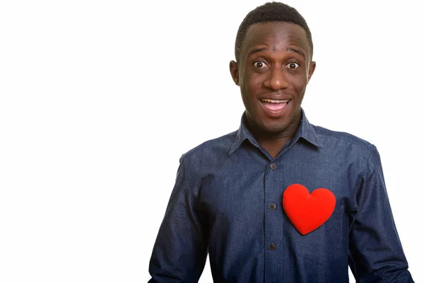 Młody szczęśliwy Afrykanin uśmiecha się z czerwonym sercem na piersi — Zdjęcie stockowe