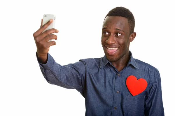 Jovem homem africano feliz sorrindo enquanto toma selfie com celular — Fotografia de Stock