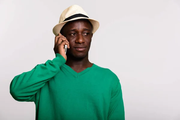 Genç Afrikalı adam düşünürken cep telefonuyla konuşuyor. — Stok fotoğraf