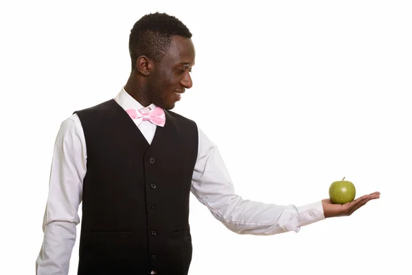 Młody szczęśliwy afrykański kelner uśmiechnięty i trzymający zielone jabłko — Zdjęcie stockowe