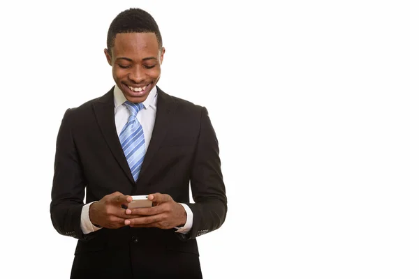 Giovane felice uomo d'affari africano sorridente e utilizzando il telefono cellulare — Foto Stock