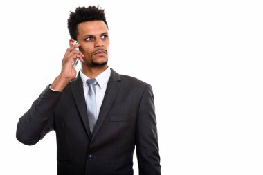 Genç Afrikalı işadamı düşünürken cep telefonuyla konuşuyor