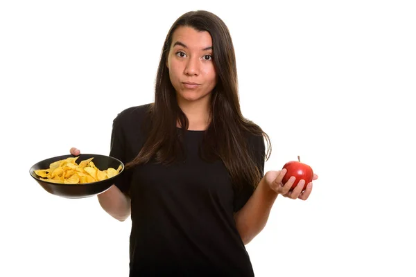 Молодая белая женщина с миской картофельных чипсов и красным яблоком — стоковое фото