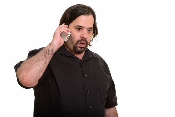 Gruby biały mężczyzna wygląda na zszokowanego podczas rozmowy przez telefon komórkowy — Zdjęcie stockowe