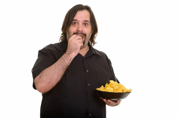 Een dikke blanke man die chips eet en vasthoudt. — Stockfoto